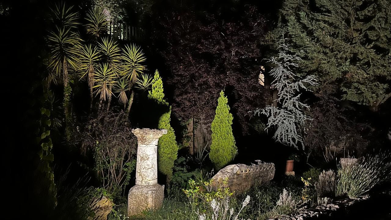 Garden lighting on a stone column and cypress